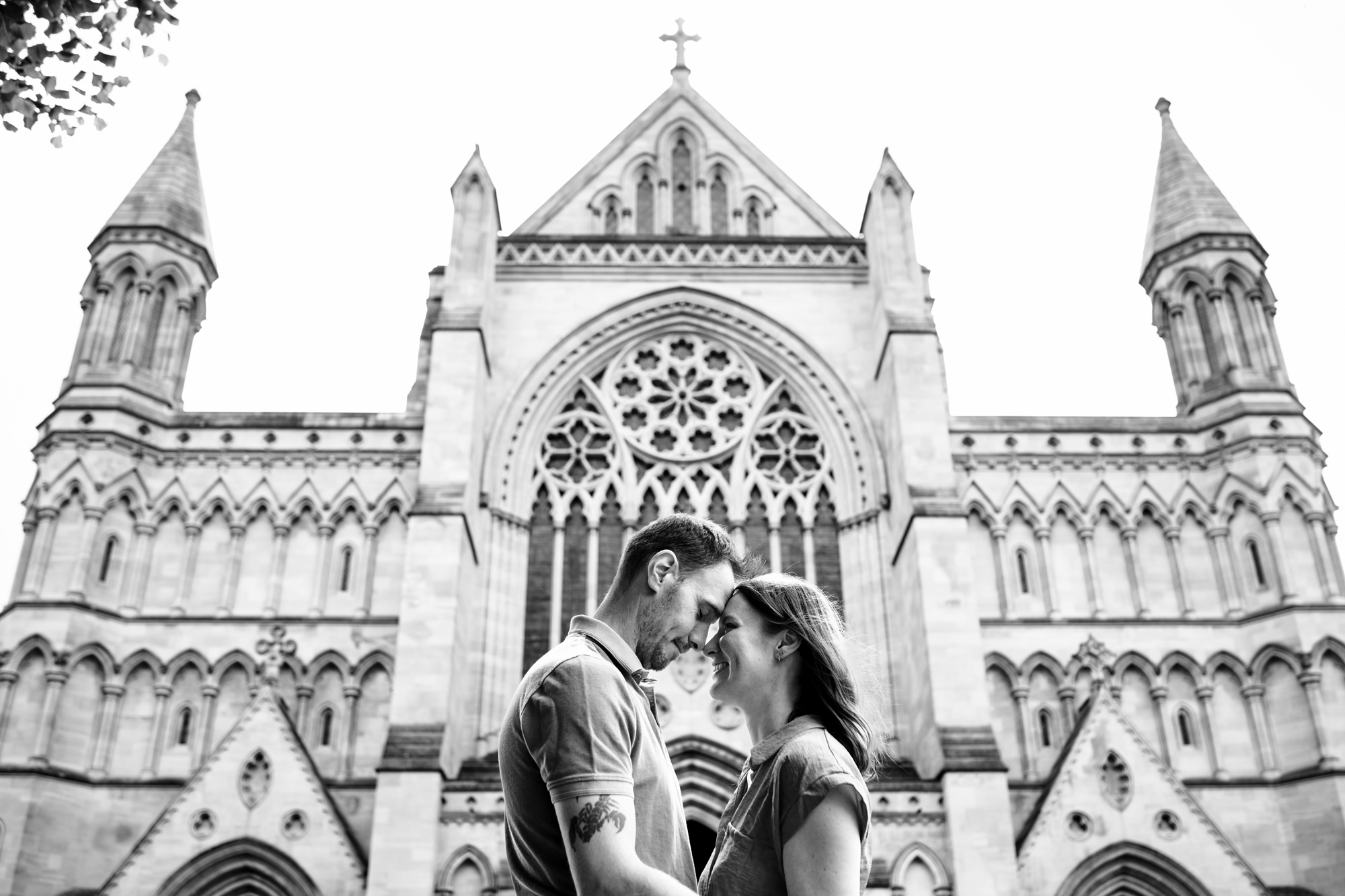 Engagement shoot in front of St Albans cathedral, bride and groom touch foreheads