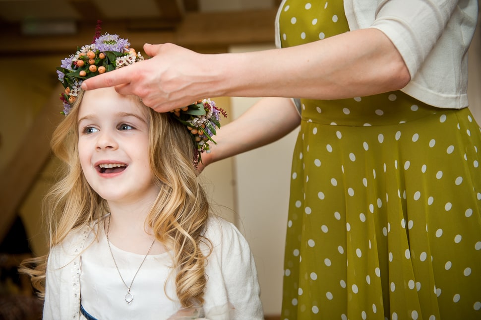 floral crown being put on flower girl
