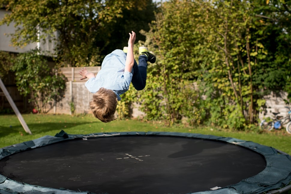 boy doing trampoline somersaults during family photoshoot
