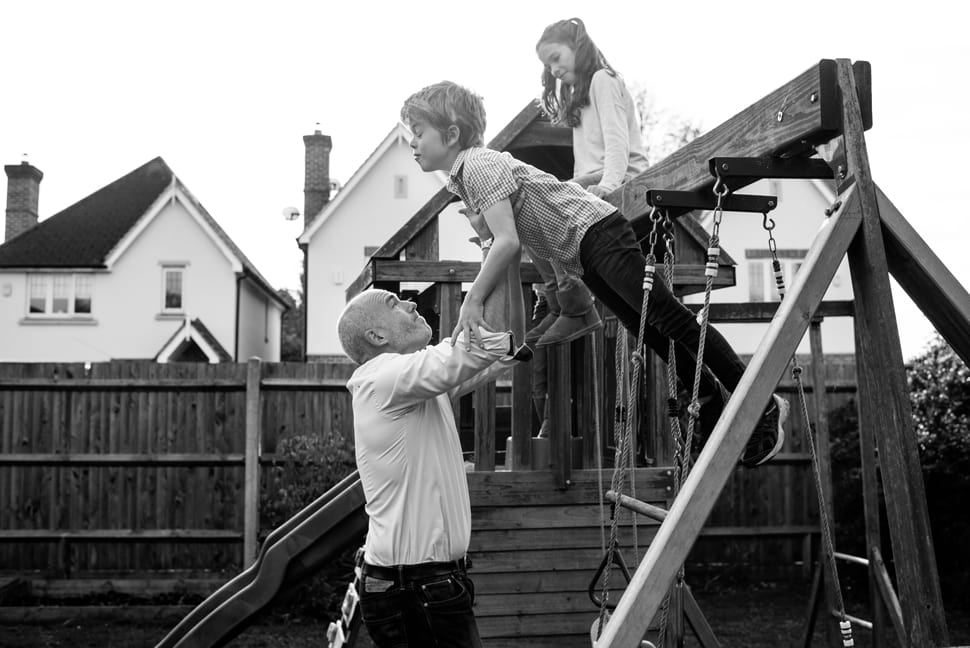 dad helping kids off top of climbing frame