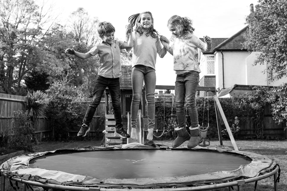 siblings having fun jumping on trampoline