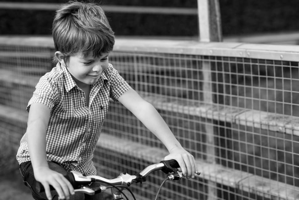 boy riding his bike along a bridge during family photoshoot