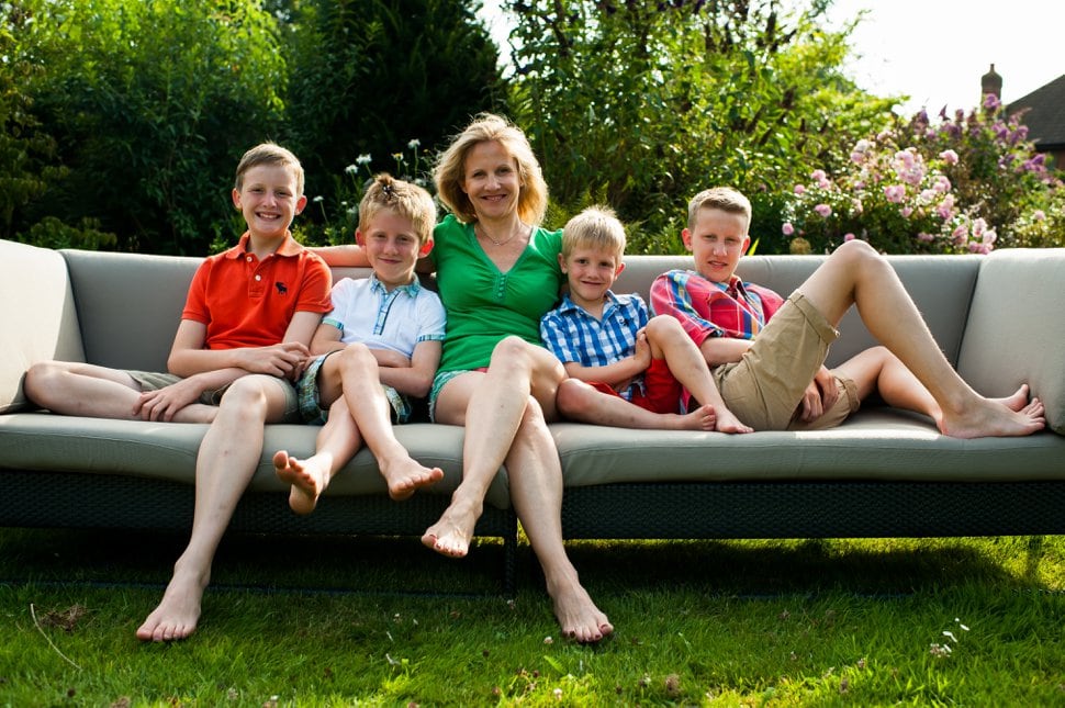 mother and four sons relaxing on garden sofa