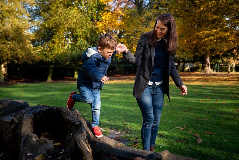mum helps son climb a fallen tree in st albans park