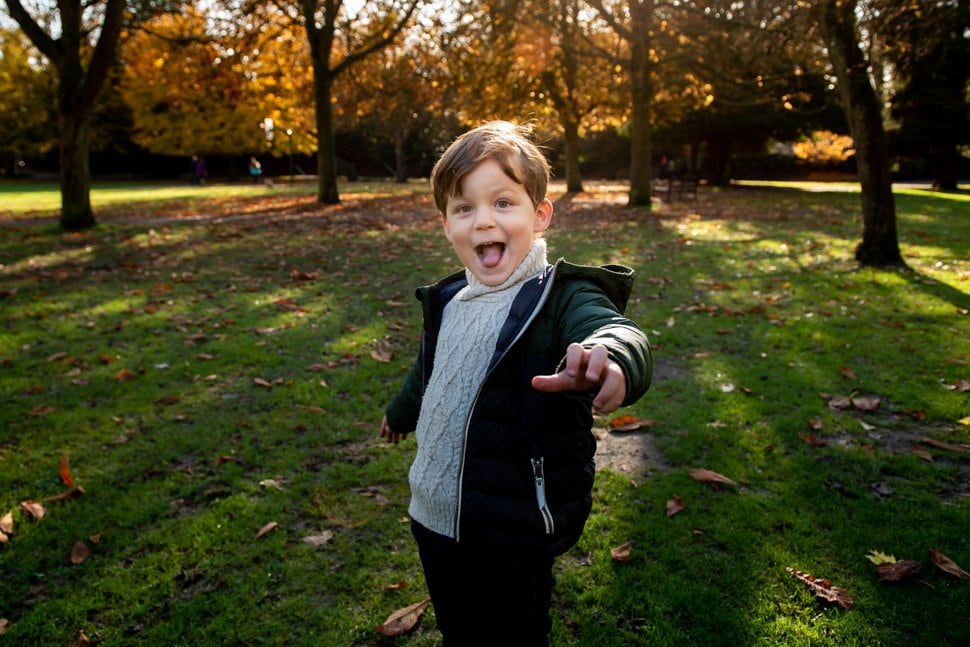 little boy pulling funny face during autumn family photo session