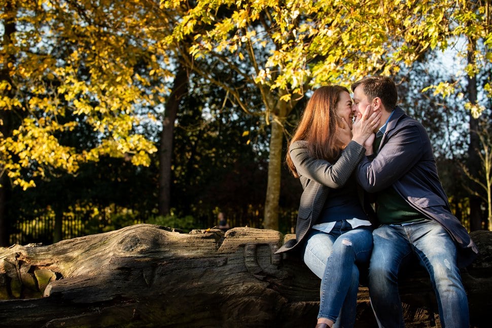 mum and dad kissing on a fallen tree seat in Clarence Park