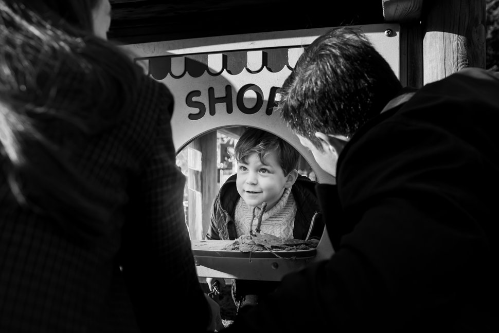 boy playing shop with mum and dad during st albans family shoot