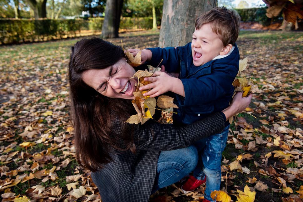 mum and son having a leaf fight during family photo shoot in St Albans