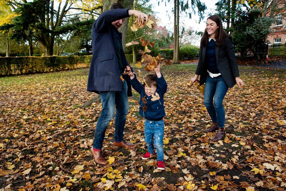 family leaf fight with raining leaves during family photo session St Albans
