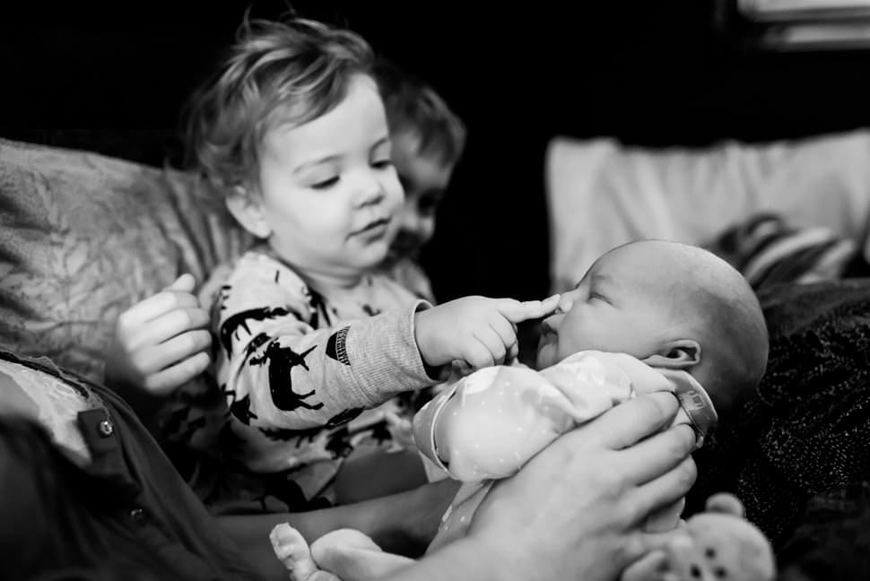 big sister squishing new baby brother nose fresh 48