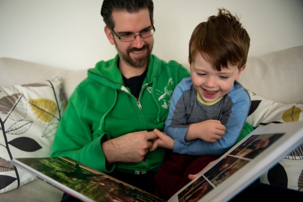 father and son look through photo scrapbook