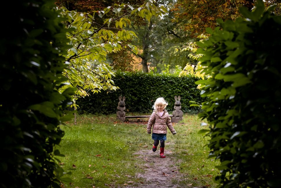little girl runs between trees