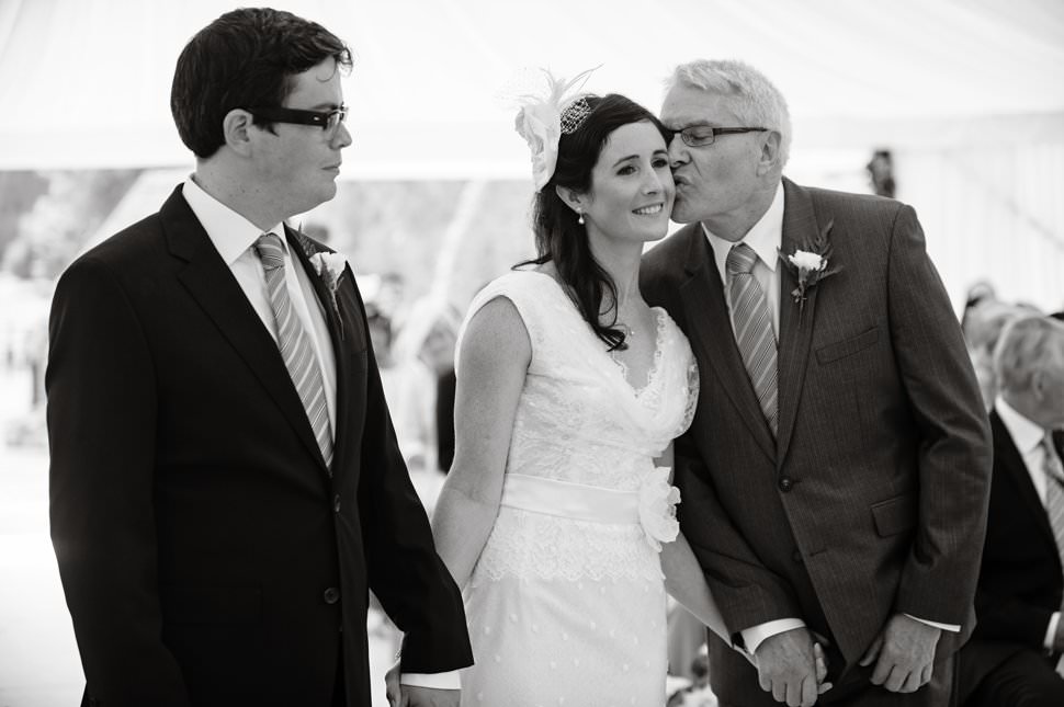dad kisses bride during Hertfordshire marquee wedding