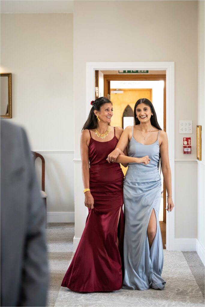 Bride is walked down aisle by daughter towards groom