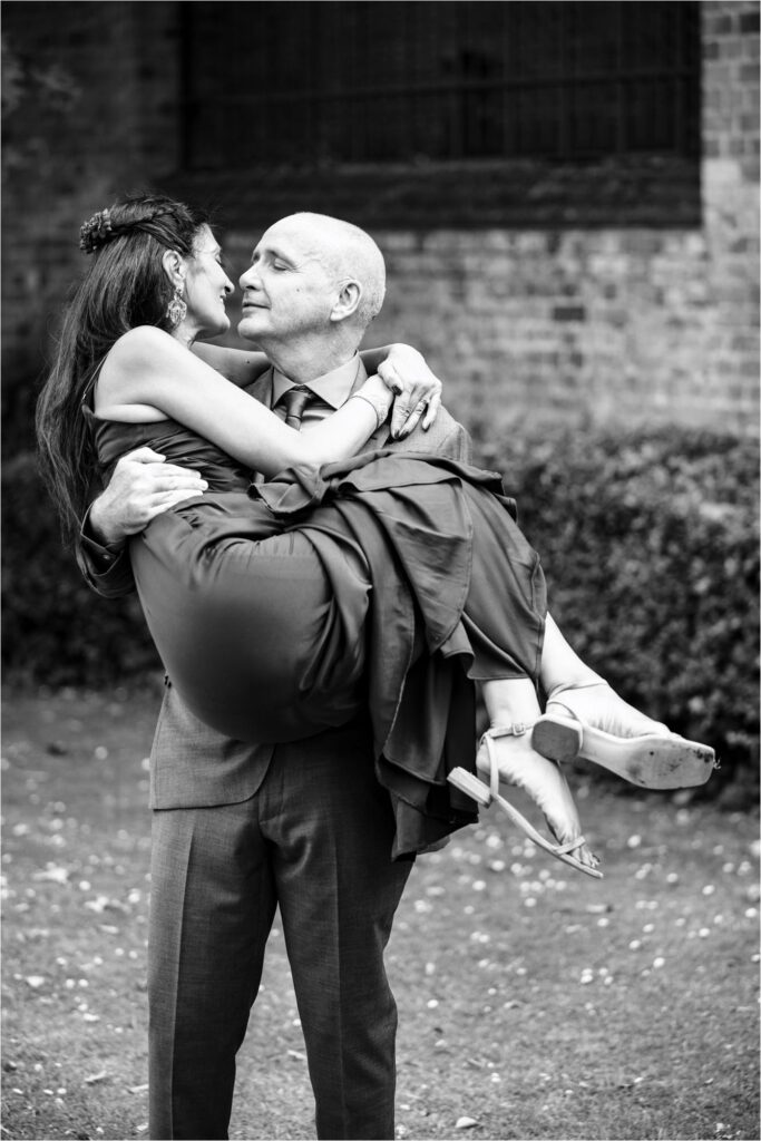 Groom picks up bride and goes to give her a kiss