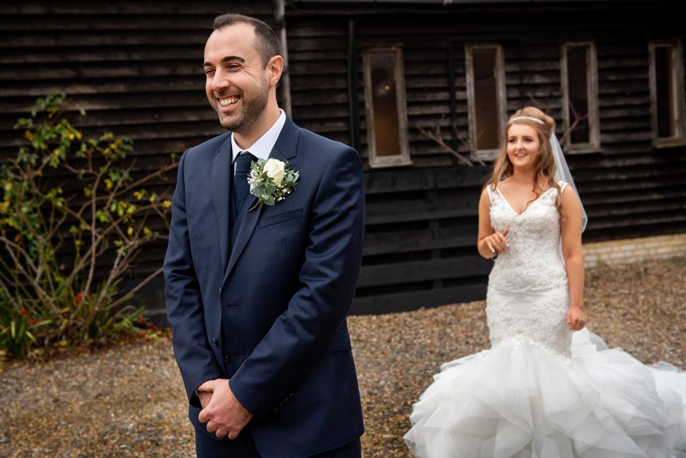 Groom waits for bride during first look at Maidens Barn