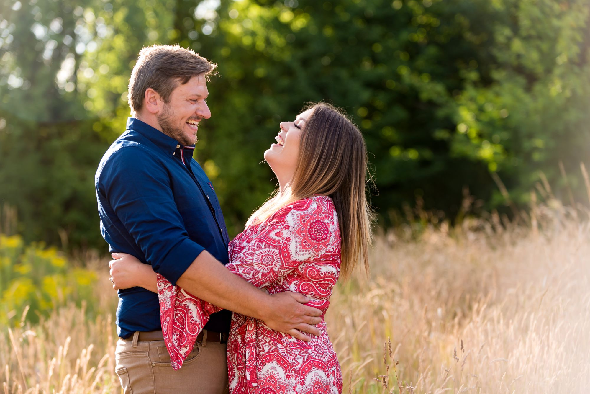 Bride and groom to be hug in long grass at private wine estate