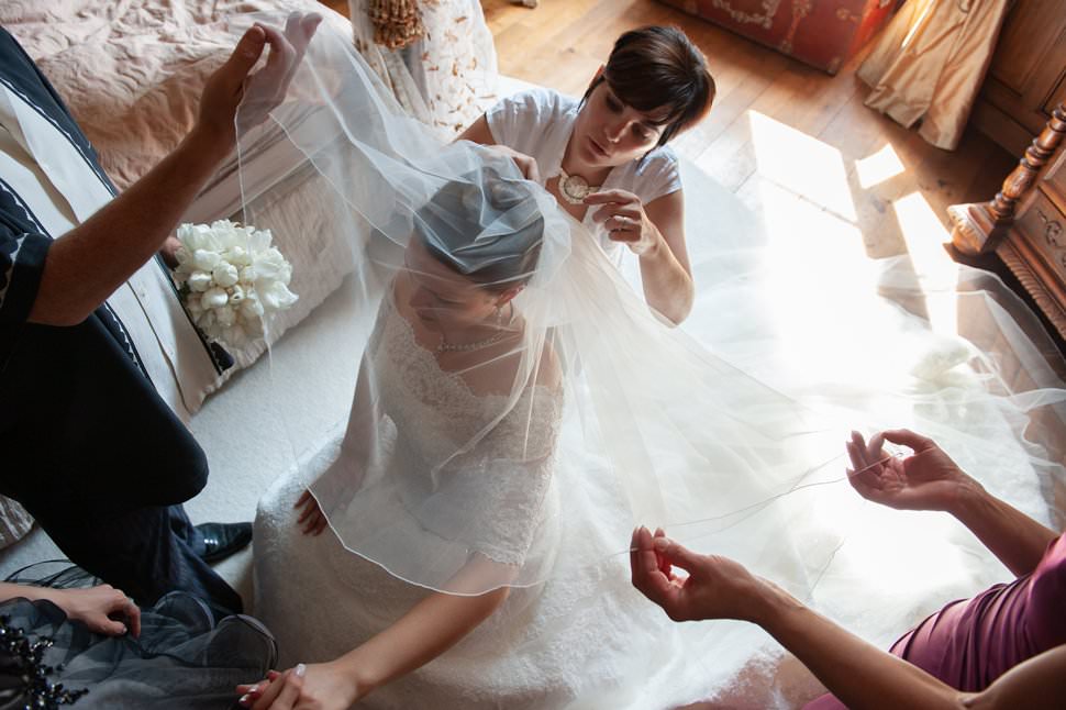 helping bride put wedding veil on