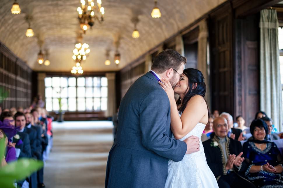 A first kiss during a Fanhams Hall wedding in the Long Gallery.