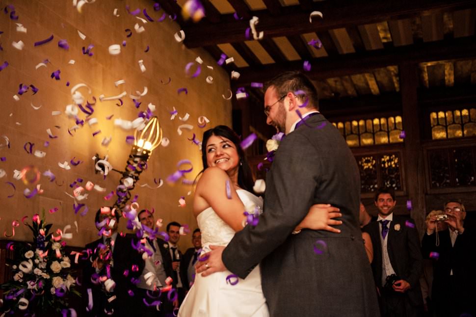 A purple and white confetti canon goes off during the first dance.