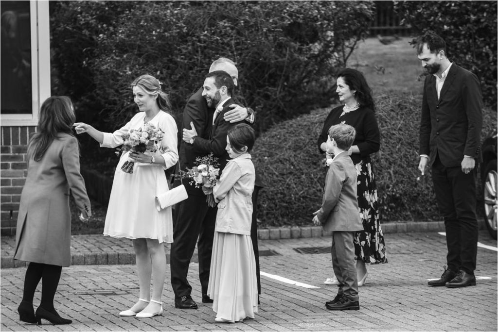 Bride and groom greet guests behind the St Albans Registry Office.