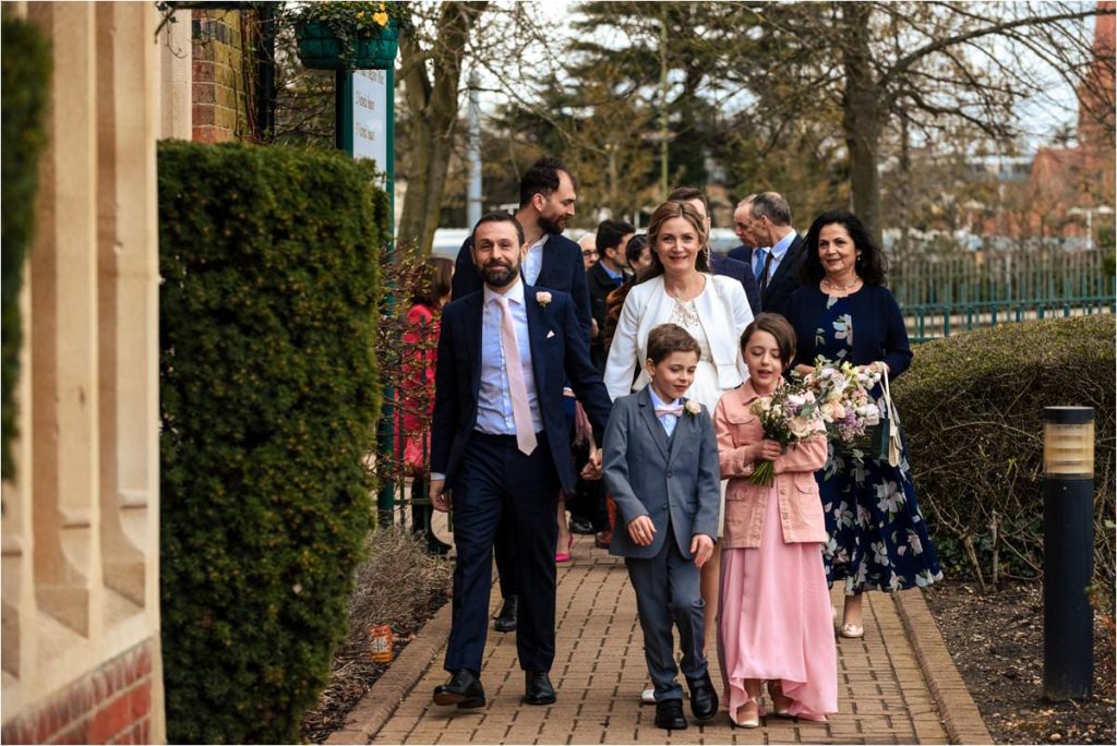 Bride, groom and family approach St Albans Registry Office for their wedding.