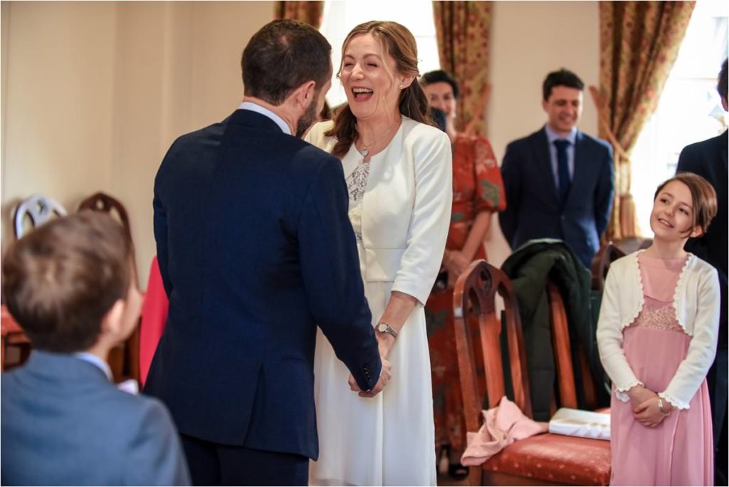 Groom makes his bride laugh during St Albans Registry Office wedding ceremony.