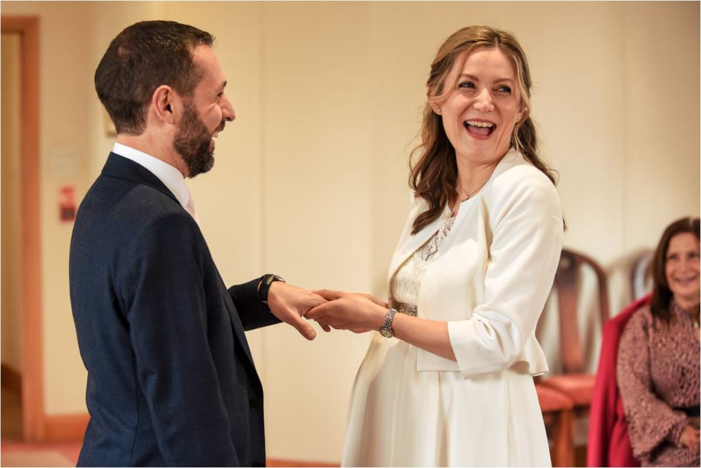 Bride laughs during St Albans Registry Office wedding ceremony.