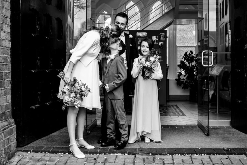 Bride kisses child outside St Albans Registry Office after getting married.