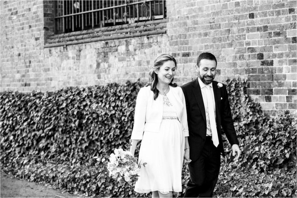 Bride and groom walk hand in hand outside St Albans Registry Office