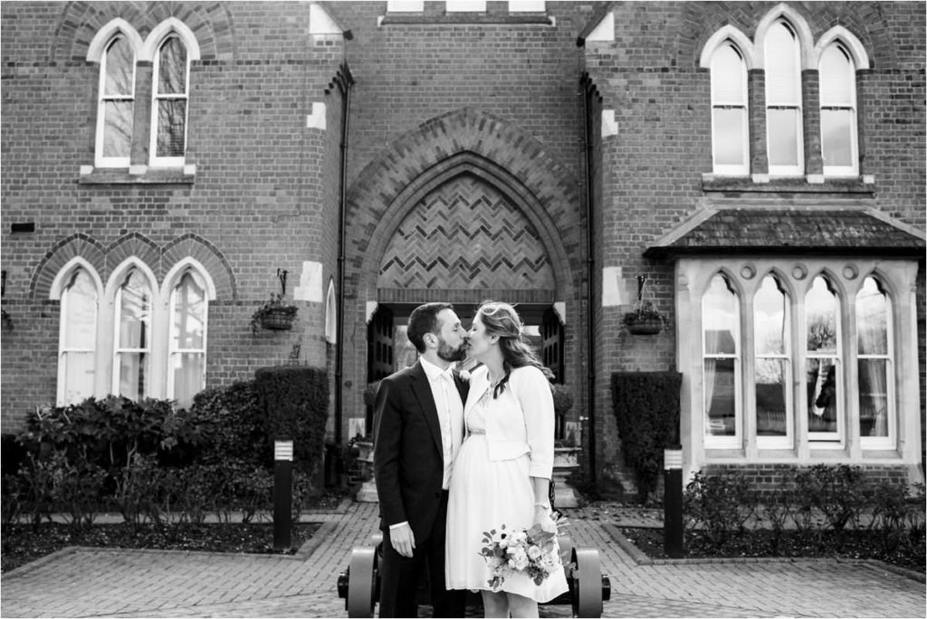 Bride and groom kiss outside St Albans Registry Office after marriage