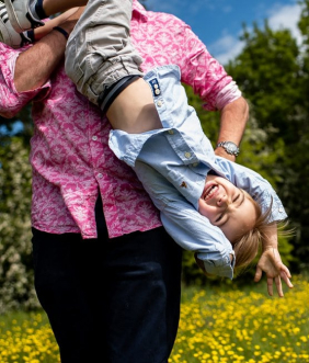 Dad holds laughing son upside down on St Albans family shoot