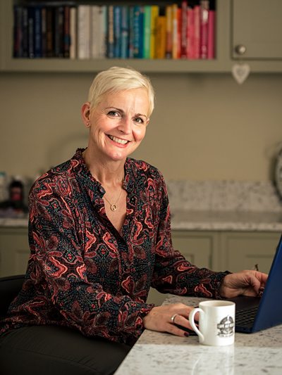 Smiling personal stylist works on computer during personal branding shoot