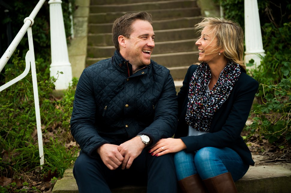Laughing couple on steps during winterengagement shoot