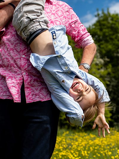 Dad holds laughing son upside down during Hertfordshire family shoot
