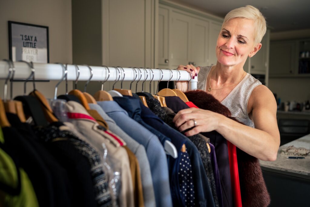 Personal stylist sorting clothes on clothes rail during personal branding shoot