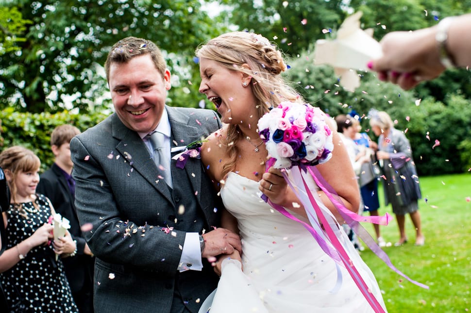 Laughing couple get doused in confetti at Hertfordshire wedding
