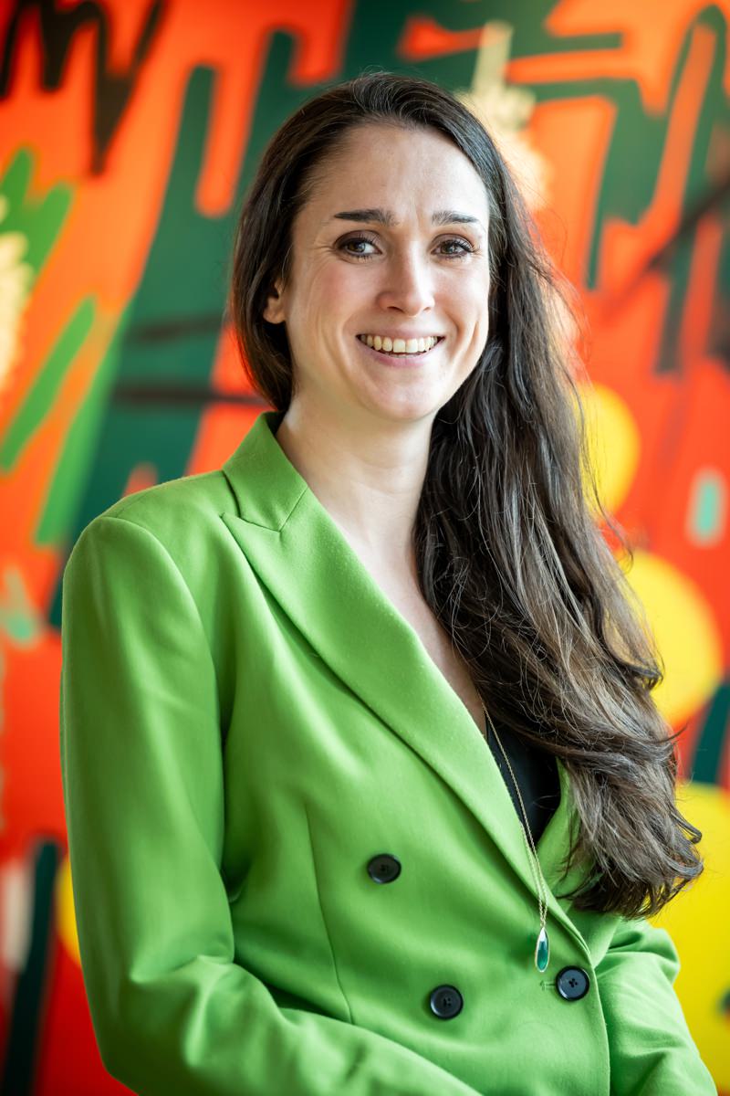 Relaxed lawyer headshot in front of colourful wall