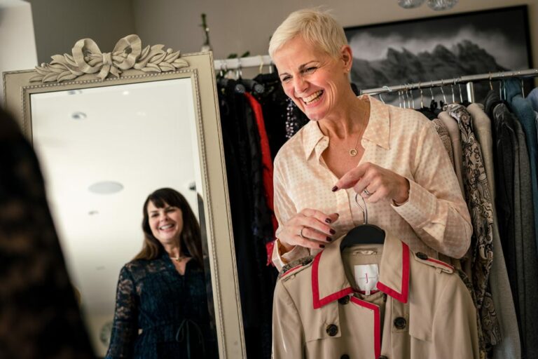 personal stylist helping client choose clothes in mirror during personal branding shoot