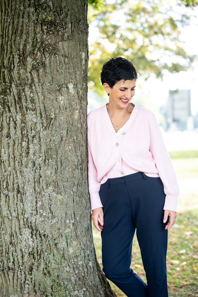 life coach leaning against tree during personal branding shoot