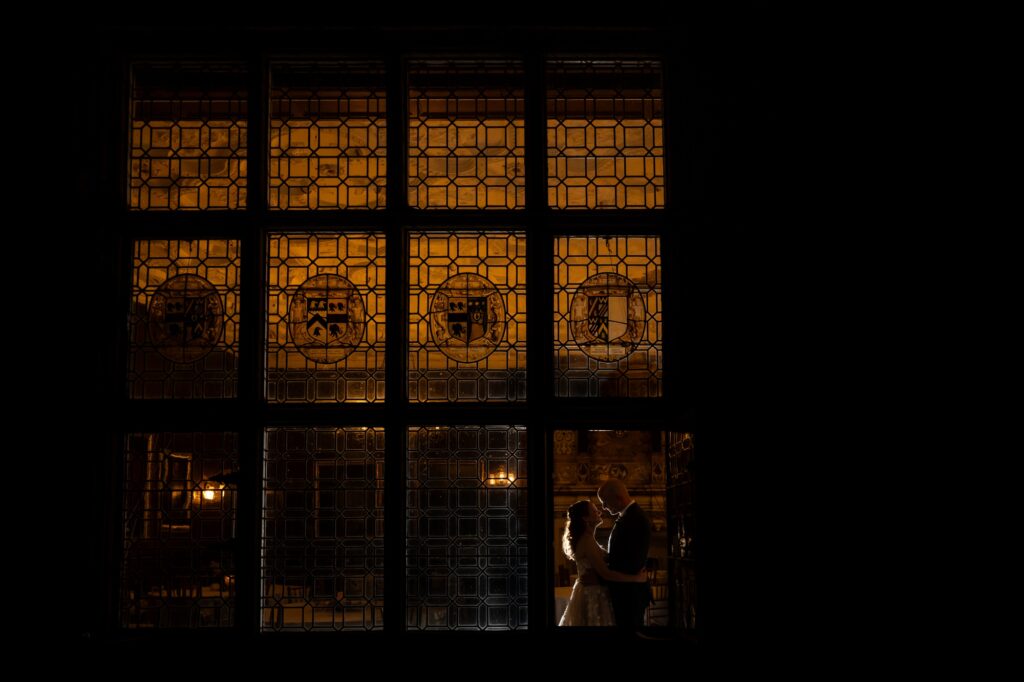 Creative nighttime photo of bride and groom silhouetted through rothamsted manor wedding 