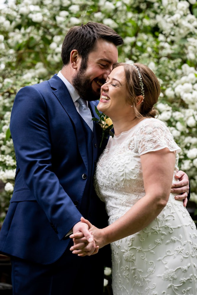 Laughing bride and groom cuddle up at St Michaels Manor wedding