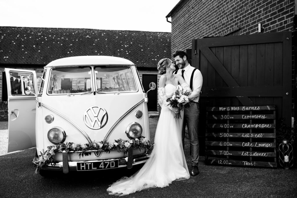 Bride and groom pose with VW camper van at Milling Barn