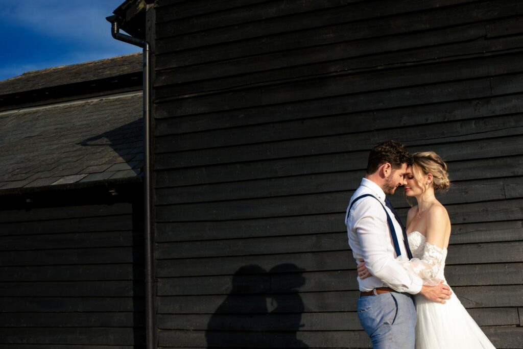 Bride and groom in setting sun in front of Milling Barn