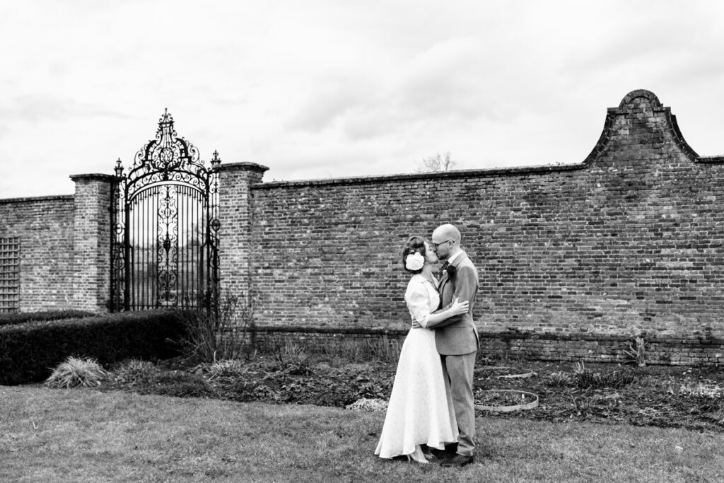 Bride and groom kiss outside of Rothamsted Manor