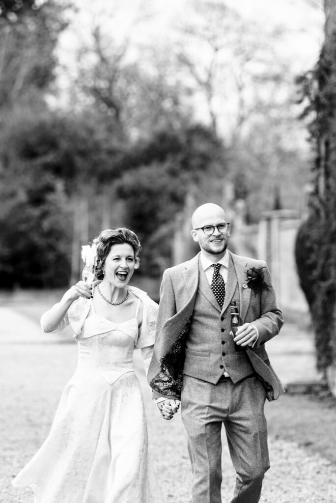 Laughing bride and groom walk outside of Rothamsted Manor
