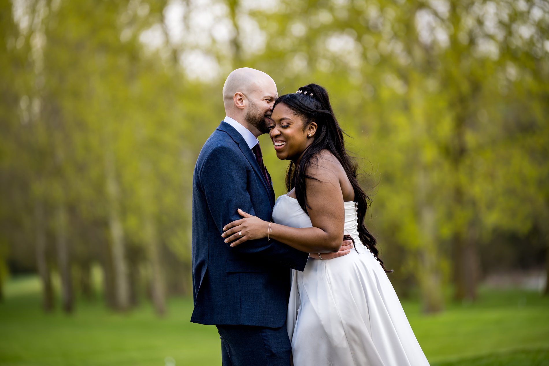 Bride laughs as groom whispers into her ear