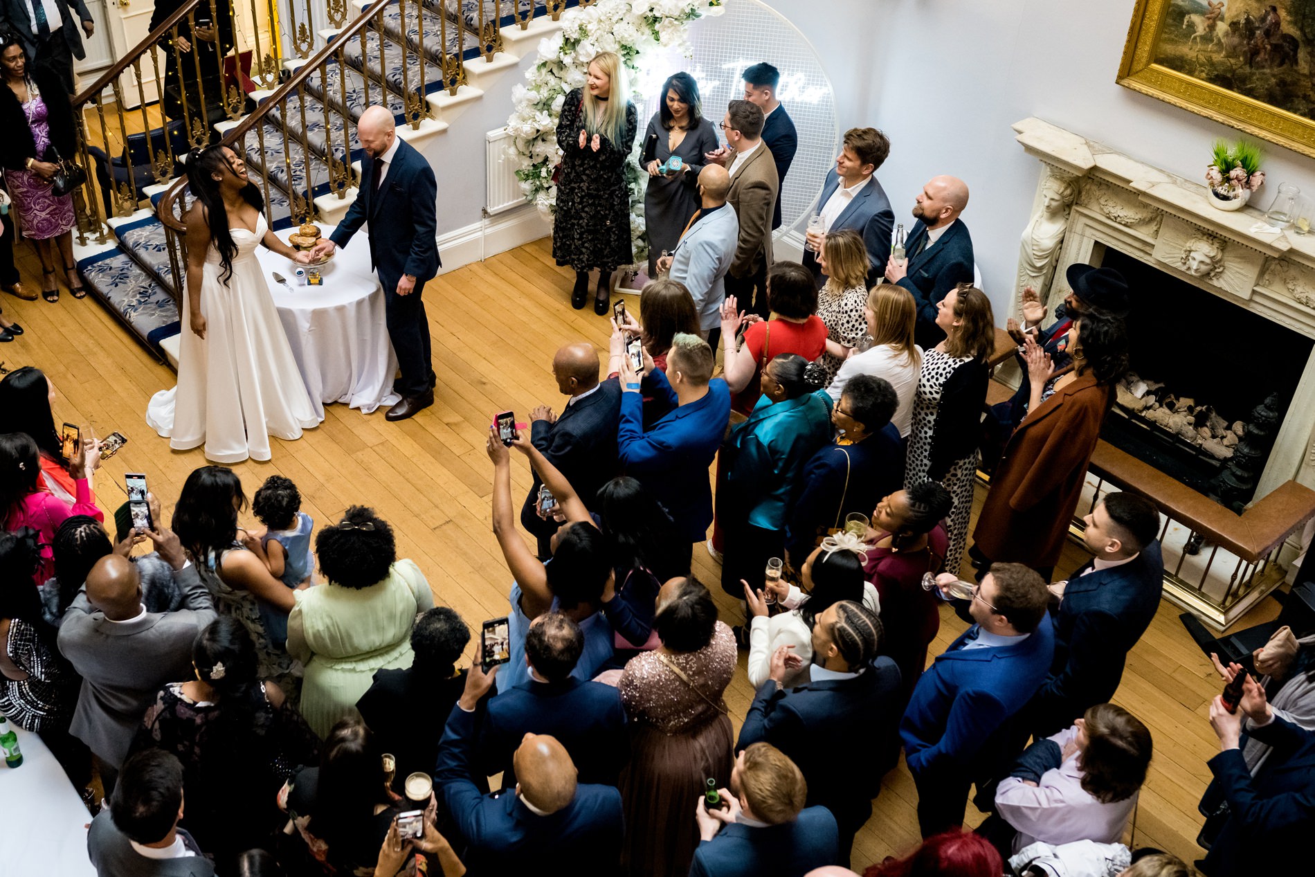 Bride and groom cut donut cake, taken from balcony