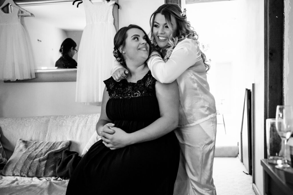 Bride hugs bridesmaid during bridal preparations