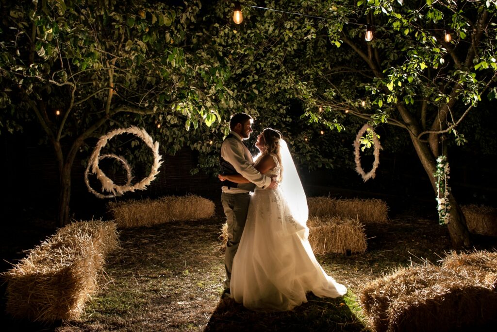 Backlit portrait of bride and groom in garden in front of pampas decorations